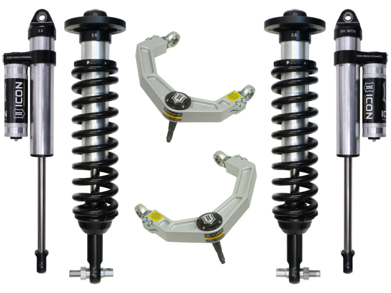 Image of a set of automotive suspension components from ICON, featuring the 2015+ Ford F-150 4WD 0-2.63in Stage 3 Suspension System with Billet UCA. The coilover shocks display black coils and silver bodies, while the upper control arms are gray with yellow labels, highlighting their Delta Joint technology for superior corrosion resistance.