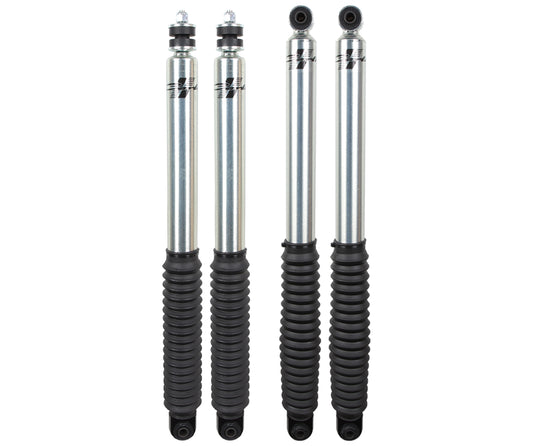 Arranged in a row, four silver shock absorbers with black rubber boots prominently display the Carli Suspension Signature Series logo on their upper section. These shocks, designed for a 2.75" lift, are ideal for boosting the performance and stability of your 94-13 Dodge Ram 2500/3500 (4WD).