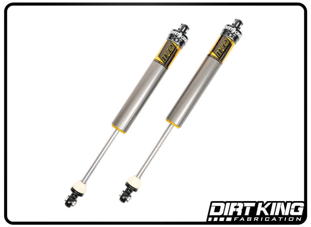 Against a white background, two silver Dirt King 19-23 GM 1500 2.0 IFP Smooth Body Shocks are showcased, featuring black and yellow accents. The bottom left corner prominently displays the "Dirt King Fabrication" logo, highlighting these DIRT KING SHOCKS as an ideal enhancement for your GM 1500 series vehicle's performance.