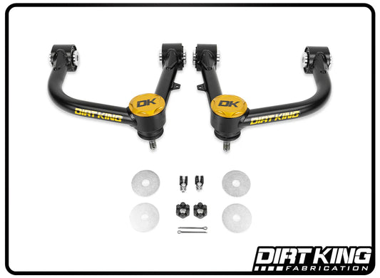 The image displays the 03-23 Toyota 4Runner Ball Joint Upper Control Arms, branded with DIRT KING's signature yellow "DK" logo. It's accompanied by a set of washers, bolts, and nuts. These components showcase enhanced suspension geometry and durable Moog ball joints, all arranged on a white background with the "Dirt King Fabrication" branding elegantly placed in the lower right corner.