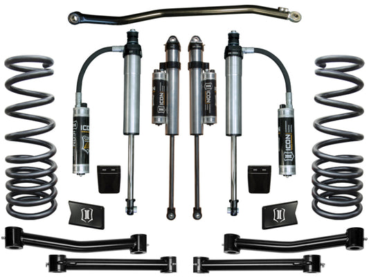 The image showcases the ICON 03-12 Dodge Ram 2500/3500 4WD 2.5in Stage 5 Suspension System, which includes two ICON-branded 2.5-inch shocks with reservoirs, a pair of coil springs, two control arms, a sway bar, and additional mounting hardware neatly displayed on a pristine white background.