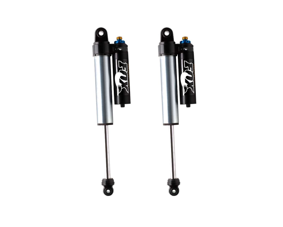 Presenting the 14-20 F-150 FACTORY RACE SERIES 2.5 RESERVOIR SHOCK (PAIR) - ADJUSTABLE by FOX, these shocks come equipped with attached reservoirs. They feature a metallic finish on the shock body, black upper and lower mounts, and blue and black adjustment knobs. The FOX logo is prominently displayed on the reservoir, making these shocks perfect for off-road race use.