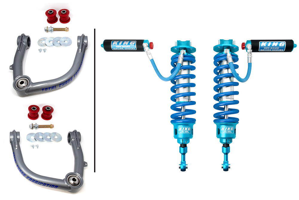 Image showing car suspension components. On the left, there are two gray control arms with bushings and hardware, arranged vertically. On the right, two blue and silver King off-road racing coilovers with external reservoirs from the TOTAL CHAOS 08-21 Toyota Land Cruiser 200 Series Lift Kit with King 3.0 Adjustable Front Shocks are placed side by side.