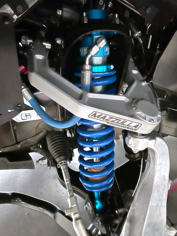 Close-up of a Toyota Tundra truck's suspension system, highlighting a blue coilover shock absorber and spring assembly with "MAZZULLA OFFROAD" branding. The intricate mechanical details feature 2022+ TOYOTA TUNDRA BILLET UPPER CONTROL ARMS, hoses, and parts of the chassis, contributing to improved handling characteristics.