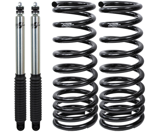 Two silver shock absorbers with black rubber bellows are positioned beside two coiled black suspension springs, all part of the Carli Suspension 94-02 Dodge RAM 2500/3500 (4WD) Diesel 2.75" Lift Leveling System, artfully arranged on a white background.