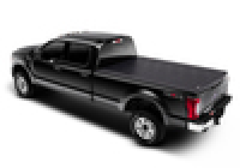 A BAK 17-23 Ford Super Duty 6ft 9in Bed Revolver X2 by BAK, featuring a black pickup truck with an aluminum roll-up cover, viewed from the back and side, highlighting its stylish design and shiny finish.