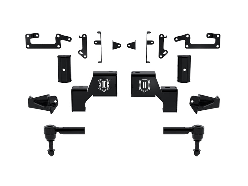 A meticulously arranged ensemble of black metal components, specifically crafted for the ICON 22-23 Toyota Tundra Lift Kit Box 1 - Front by ICON, is displayed against a white backdrop. This collection includes brackets and mounts, along with two cylindrical pieces featuring cutouts or holes designed for attachment. Each component is engineered to deliver exceptional off-road suspension performance.