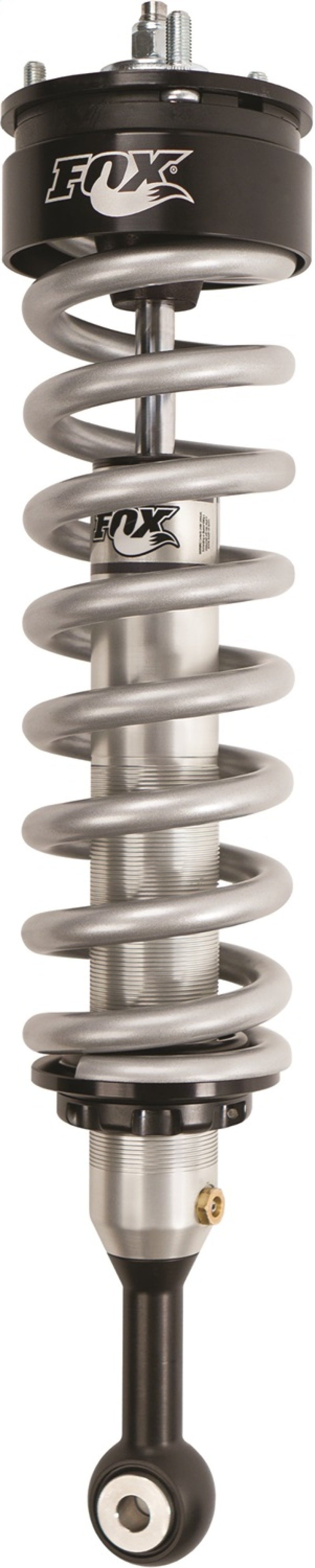 A close-up of the Fox 05+ Toyota Tacoma 2.0 Performance Series IFP Coilover Shock displays its silver coil and black mounting points, with the FOX logo clearly visible on the top section. Designed for enhanced off-road performance, its aluminum body ensures durability and supports a lift of 0-2 inches.