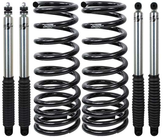 A Carli Suspension 03-09 Dodge RAM 2500/3500 (4WD) Leveling Starter System, featuring four metal coil springs and four shock absorbers with black rubber covers and shiny metallic rods, arranged vertically on a white background.