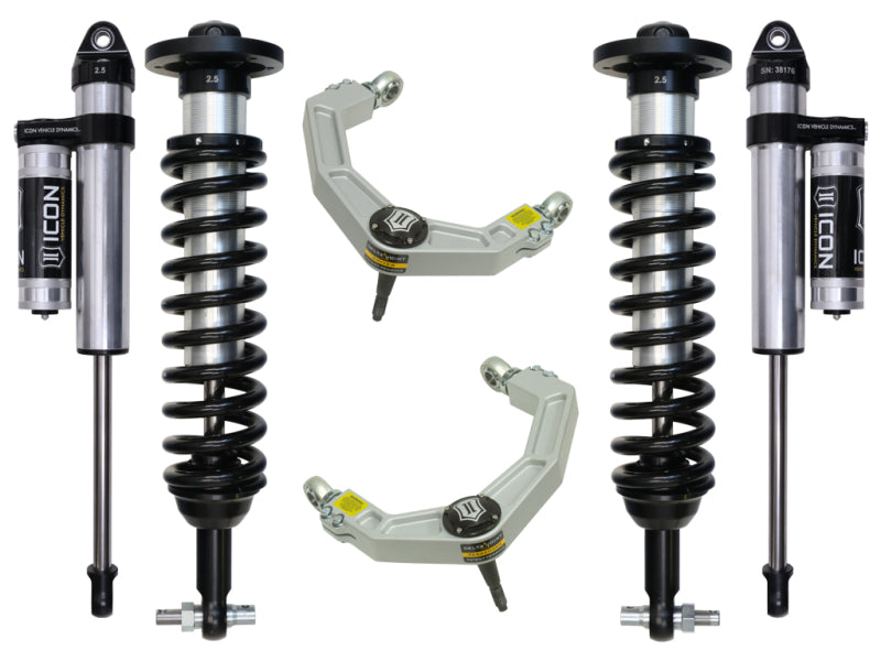 The image showcases four components from the ICON 2015+ Ford F-150 2WD 0-3in Stage 3 Suspension System. On the sides are two coilover shock absorbers featuring black coils and silver cylinders, while centrally positioned are two upper control arms with a metallic finish and visible ICON branding, enhanced with corrosion resistance due to their advanced Delta Joint design.