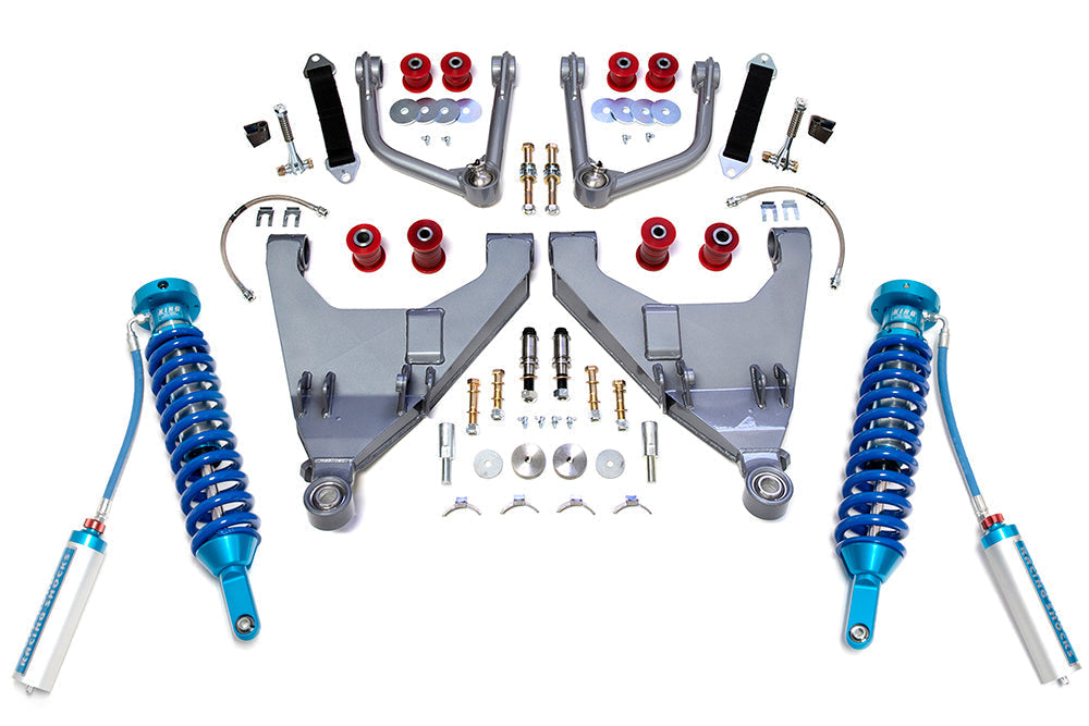 A 10-22 Toyota 4Runner KDSS +2 Inch Expedition Series Long Travel Kit with King Coil Overs by TOTAL CHAOS laid out on a white background, featuring two blue coilover shocks with reservoirs, extended control arms, uniballs, bolts, washers, spacers, bushings, and other hardware components designed to enhance wheel travel.