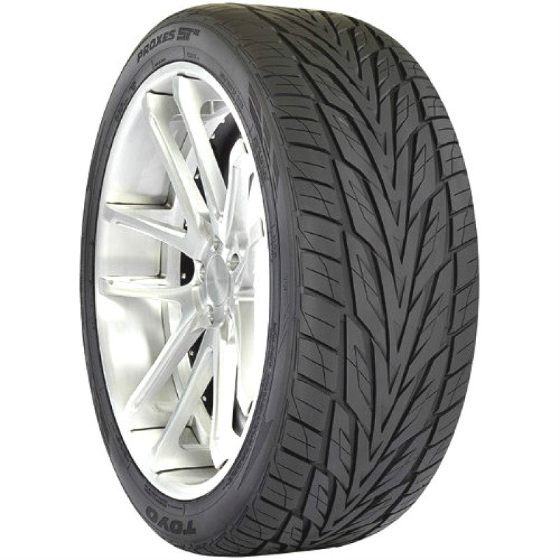 The TOYO Proxes ST III Tire, with a size of 285/50R20 116V, offers an intricate tread design for improved grip and stability. This high-performance tire showcases a black rubber surface rich in textures, beautifully accentuating its elegant silver alloy wheel.