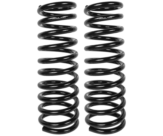 Two black coil springs from the Carli Suspension 03-13 Dodge RAM 2500/3500 Diesel (4WD) Coil Spring Set for a 3" lift are standing upright side by side against a white background.