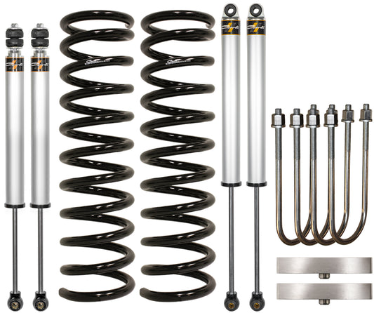 This Carli Suspension 19-23 Ram 3500 (4WD - Leaf) Diesel 2.5" Lift Carli-Spec Leveling System & 1" Block includes two shock absorbers, two coil springs, four U-bolts, and two mounting plates. The components are neatly arranged on a white background.