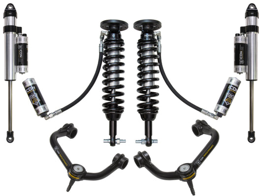 The ICON 2015+ Ford F-150 2WD 1.75-3in Stage 5 Suspension System with Tubular Uca includes two coilover shock absorbers with springs and connected reservoirs, as well as two upper control arms. These components are enhanced with Delta Joint technology for superior corrosion resistance and are neatly displayed against a pristine white background.