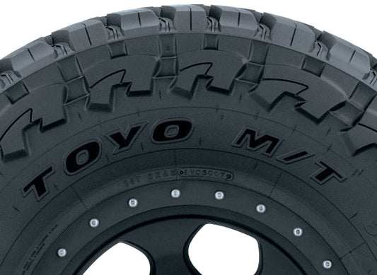 Close-up of a black tire featuring a rugged tread pattern. The "TOYO" brand and the distinctive design of the Open Country M/T are prominently displayed on the sidewall. Expertly engineered, this Toyo Open Country M/T Tire in size 42X13.50R17 126Q is perfect for off-road vehicles.