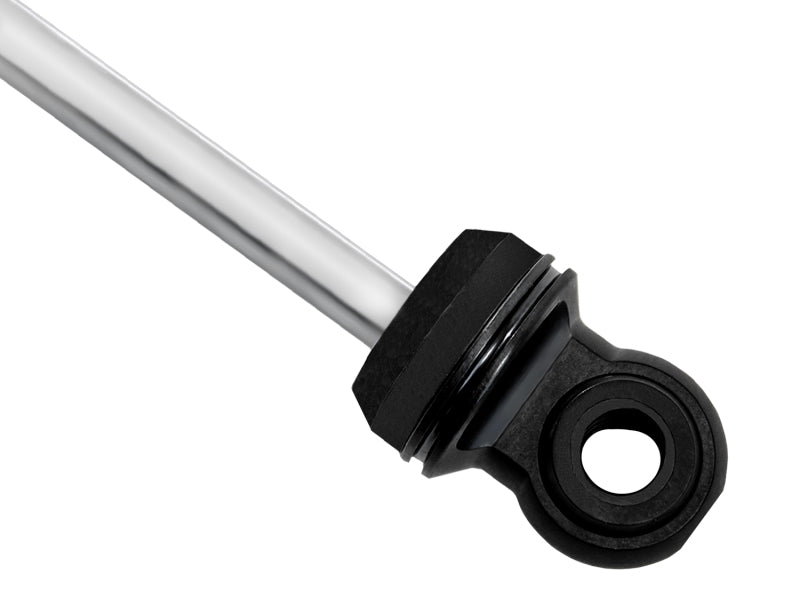 A close-up image highlights a sleek, metallic rod with a black circular eyelet at one end, similar to those found in the FOX 05+ Toyota Tacoma Performance Elite 2.5 Series Shock Rear. The smooth and reflective rod contrasts sharply with the matte-finished eyelet, which is crucial for enhancing wheel travel in mechanical applications.