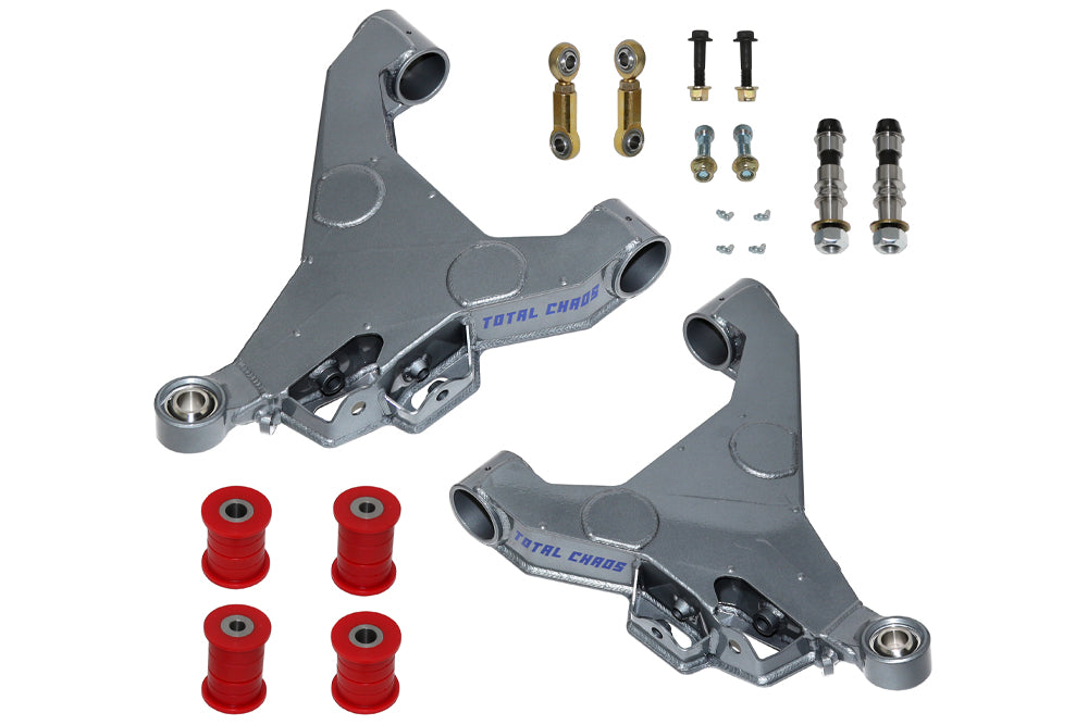 The image displays a set of lightweight silver lower control arms designed for off-road suspension on 2007-2021 Toyota Tundra vehicles. Crafted from durable 4130 chromoly, this Expedition Series set features red bushings, smaller metal components, bolts, and nuts. Each CNC-machined control arm prominently bears the "TOTAL CHAOS" branding.