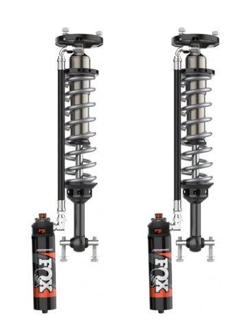 Two FOX 21-23 F-150 Performance Elite Series 2.5 Coil-over Reservoir Shocks, each featuring silver coils and black cylinders connected to a black and silver external reservoir with a Dual Speed Compression adjuster. The shocks are standing upright side by side against a white background.