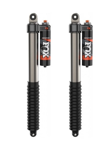 Two 21-23 F-150 PERFORMANCE ELITE SERIES 2.5 RESERVOIR SHOCKS (PAIR) by FOX are shown. The cylindrical silver shocks feature black accordion boots at the lower ends and black remote reservoirs attached near the top. A prominent FOX logo is displayed on the reservoirs, and orange DSC Adjusters are visible.