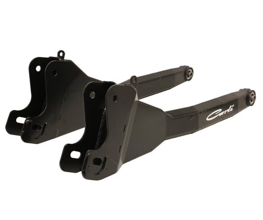 A pair of black spindle assemblies with a sleek design, perfectly compatible with the 13-23 RAM 2500/3500 (4WD) Fabricated Radius Arm System for a 2.5" lift from Carli Suspension. They come with bolt-hole mounts and feature a logo on the side, showcasing a polished metal surface that embodies the superior craftsmanship of Carli's products.