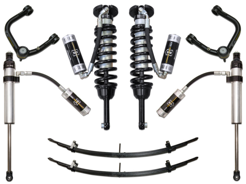 The ICON 05-15 Toyota Tacoma Stg 5 Suspension System with Tubular UCA is displayed against a white background, showcasing an array of components including shock absorbers, coil springs, leaf springs, and corrosion-resistant upper control arms from the ICON brand. Each metallic part is accented in black and interconnected with hoses.