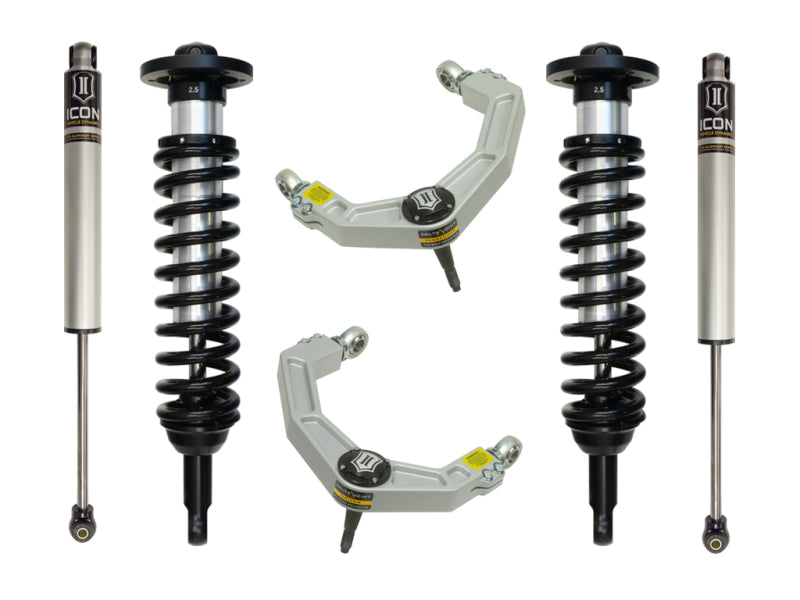 A suspension kit branded as ICON, designed for the 04-08 Ford F-150 2WD with a lift range of 0-2.63 inches, showcases a pair of shock absorbers with coil springs and billet upper control arms featuring Delta Joint technology. These components are arranged symmetrically on a white background and exhibit black and metallic finishes adorned with the ICON logo, ensuring enhanced corrosion resistance for enduring performance.