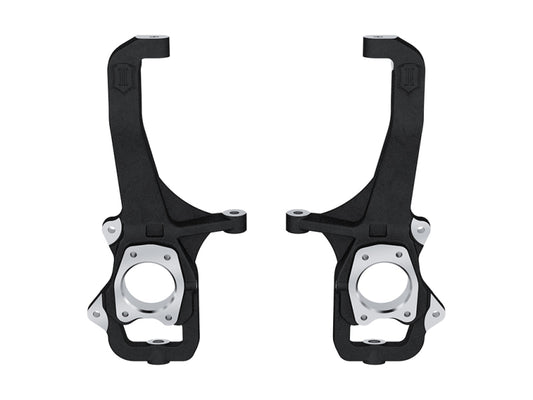 Two black and silver steering knuckles, part of the ICON 22-23 Toyota Tundra Front Knuckle Kit by ICON, are displayed side by side on a white background. These components feature a robust, industrial design with multiple attachment points and circular openings.