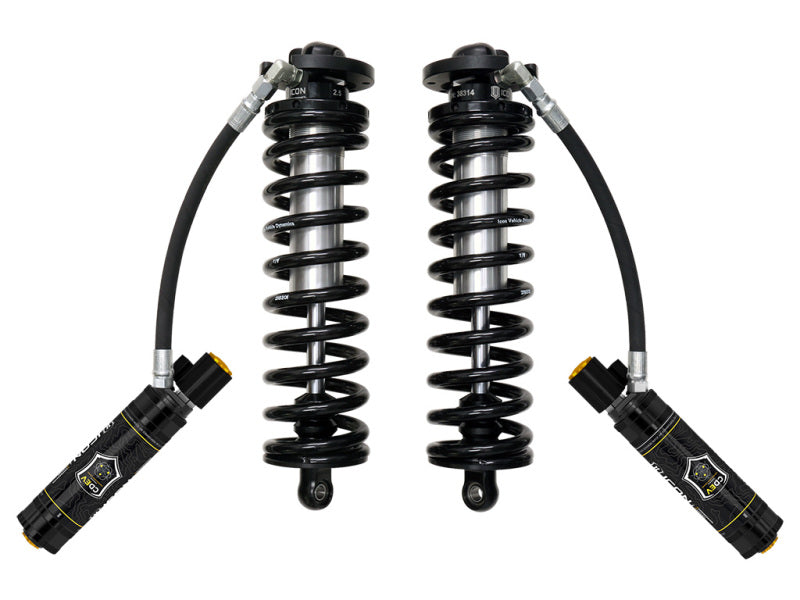 The ICON 2017+ Ford F-250/F-350 SD 4WD 2.5-3in 2.5 Series Shocks VS RR CDEV Bolt-In Conversion Kit, featuring two black shock absorbers with coiled springs and hydraulic reservoirs on flexible hoses, is displayed side by side against a plain white background and is compatible with F-250 and F-350 trucks.