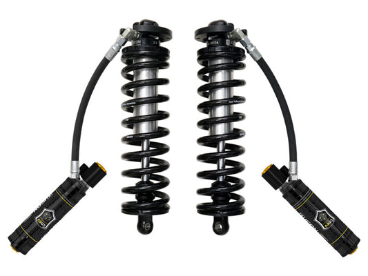 The ICON 2017+ Ford F-250/F-350 SD 4WD 2.5-3in 2.5 Series Shocks VS RR CDEV Bolt-In Conversion Kit, featuring two black shock absorbers with coiled springs and hydraulic reservoirs on flexible hoses, is displayed side by side against a plain white background and is compatible with F-250 and F-350 trucks.