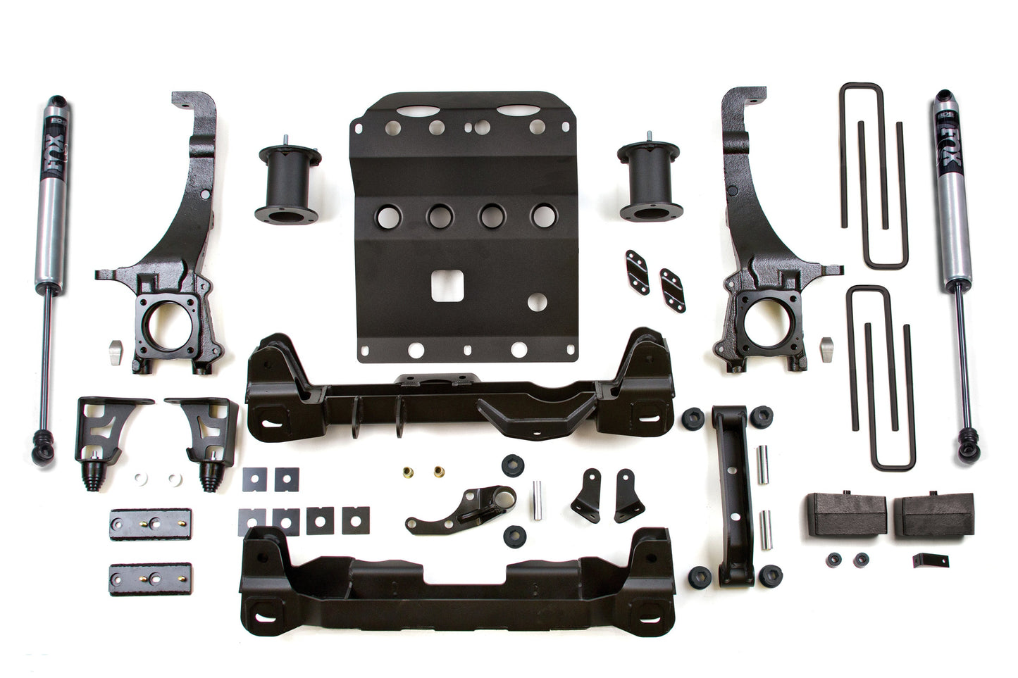 Components of the BDS 4 Inch Lift Kit for the Toyota Tacoma (05-15) 4WD are arranged on a white background. This includes shock absorbers, brackets, spacers, bolts, nuts, a large metal plate, among other parts. The kit provides essential offroad protection and features symmetrically organized parts.