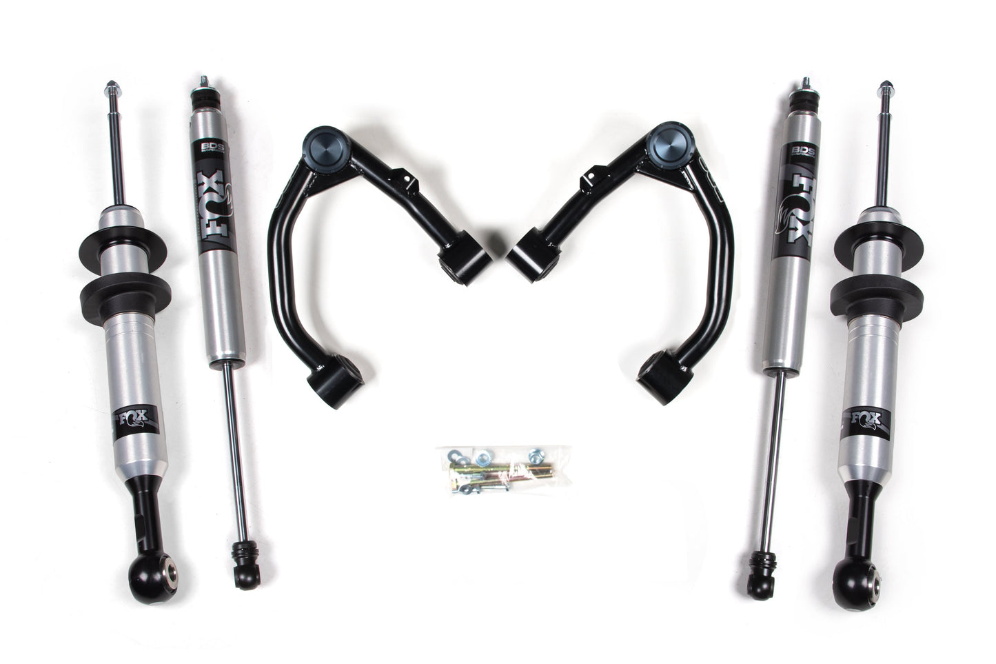 Image of BDS 2 Inch Lift Kit for Toyota Tundra (07-21) 2/4WD, showcasing four FOX 2.0 Snap Ring Strut shocks with silver bodies and black accents, two black control arms positioned in the middle, and a small bag containing various bolts and washers placed at the center bottom.