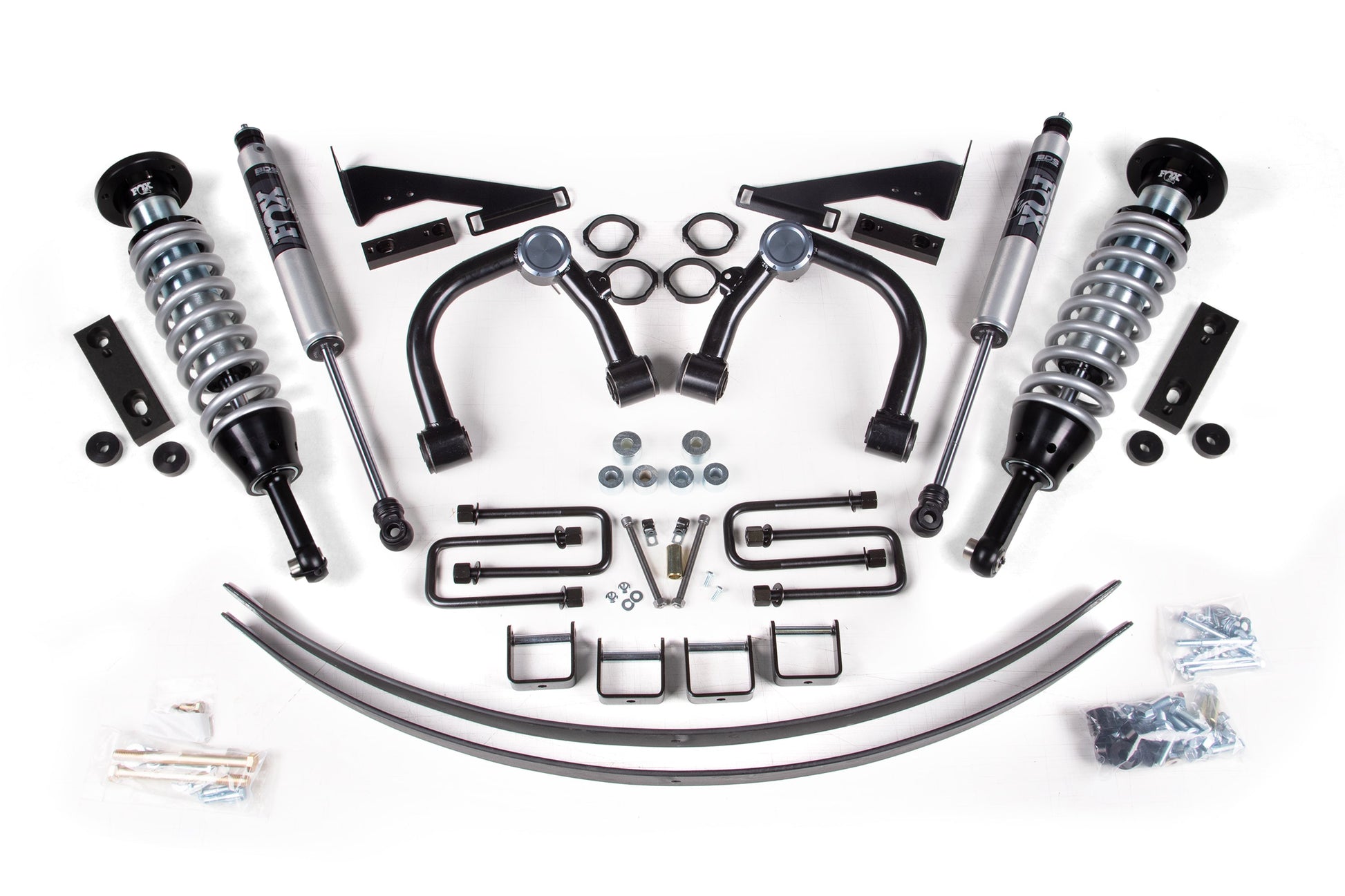 A 2-inch lift kit for a Toyota Tacoma (2016-2023) 4WD is displayed on a white background, featuring FOX 2.5 IFP coil-over shocks, coil springs, control arms, brackets, bolts, washers, and U-bolts symmetrically placed to showcase the complete BDS Suspension product.