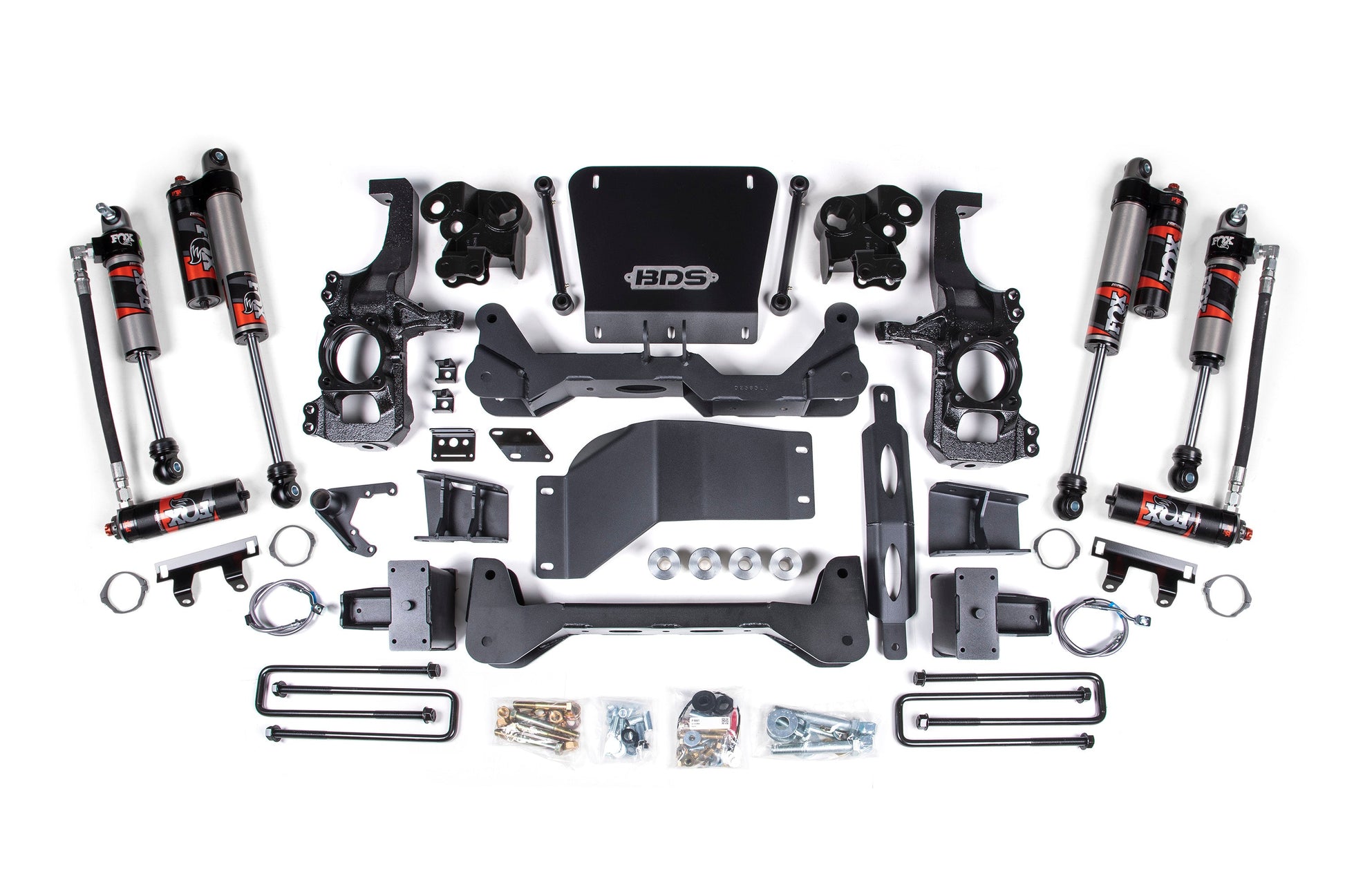 A neatly arranged assortment of automotive suspension lift kit components, including shocks, brackets, steering knuckles, crossmembers, and hardware, displayed on a white background. The components are predominantly black and red with the BDS logo prominently featured on a central piece. This set is ideal for a 5 Inch Lift Kit | FOX Performance Elite | Chevy Silverado or GMC Sierra 2500HD/3500HD (20-24) 4WD from BDS.