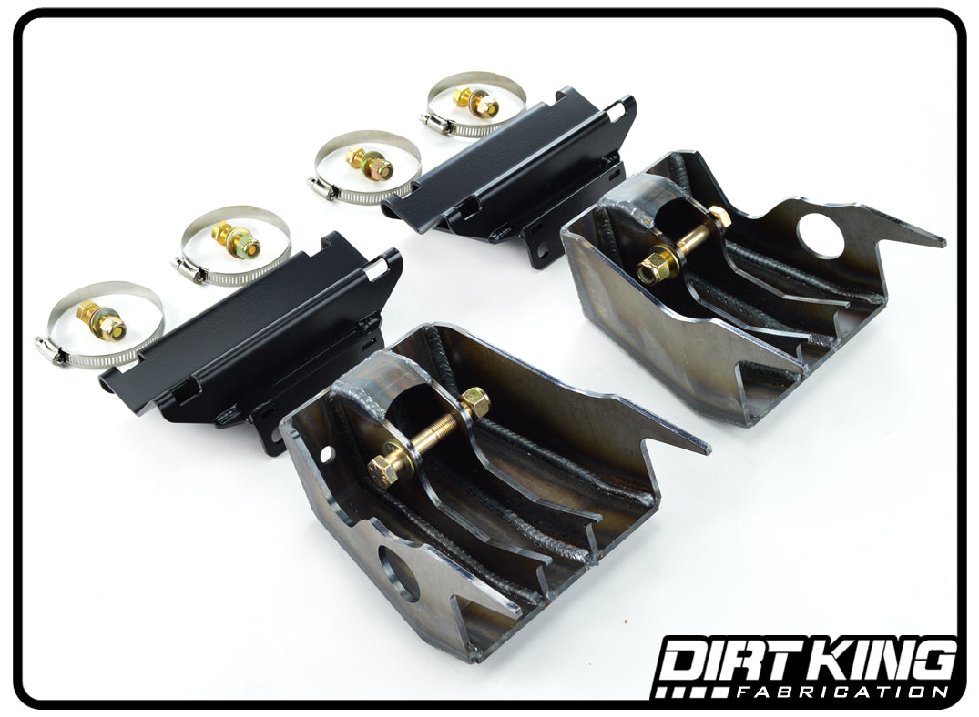 A photograph showcasing the 09-18 RAM 1500 2WD Shock Towers from DIRT KING. The image features two sets of mounts, complete with bolts, washers, and clamps. The mounts display intricate welding and cutout designs, specifically crafted for the Ram 1500 shock towers. The DIRT KING logo is visible in the bottom right corner.