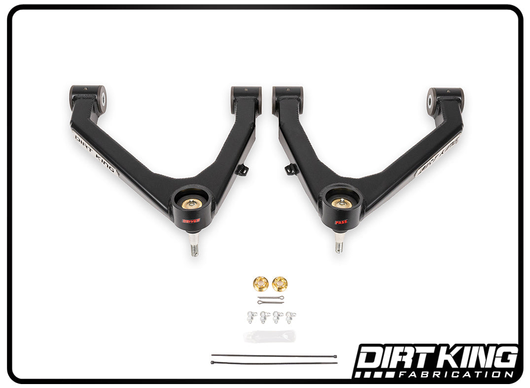 Two black boxed upper control arms from DIRT KING, designed for the 07-18 GM 1500 series, feature red bushings and heavy-duty Moog joints to enhance castor. Arranged beneath are two bolts, smaller screws, washers, a pair of yellow components, and zip ties. The brand name "DIRT KING" is displayed in the bottom right corner.