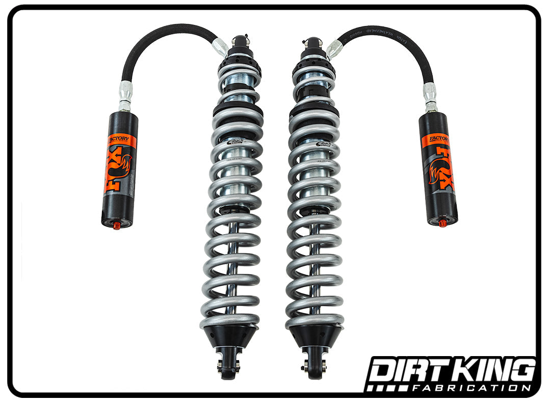 Close-up view of two Dirt King 07-18 GM 1500 Long Travel Spec Fox Coilovers by DIRT KING SHOCKS. The coilover shocks feature black and silver springs connected to black and red Fox-branded reservoirs, designed for superior off-road performance. The Dirt King Fabrication logo is visible in the bottom right corner.