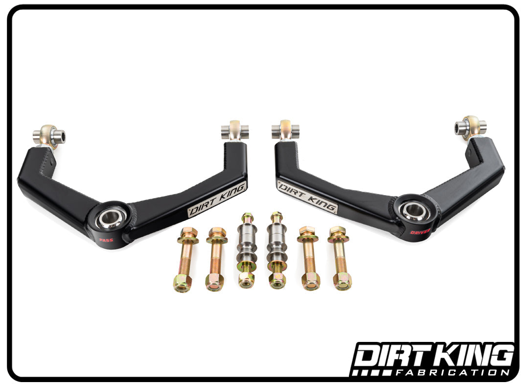 An image showcasing DIRT KING's 09-18 RAM 1500 4WD Heim Boxed Upper Control Arms. This set comprises two control arms, clearly marked for the driver's and passenger's sides, and includes durable stainless steel uniballs as well as all necessary bolts and hardware. The DIRT KING logo is prominently displayed in the bottom right corner.