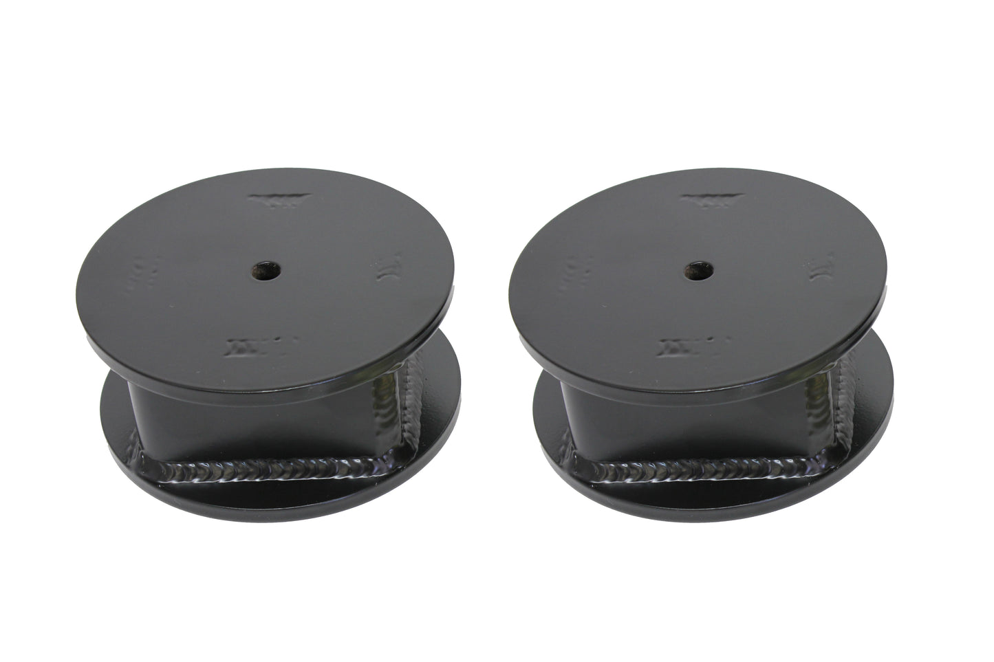 Two black metal spools with central holes, similar to the Carli Suspension Long Travel Air Bag Spacer for a 6" lift on a 03-13 Dodge RAM 2500/3500 (4WD), are positioned side by side against a plain white background.