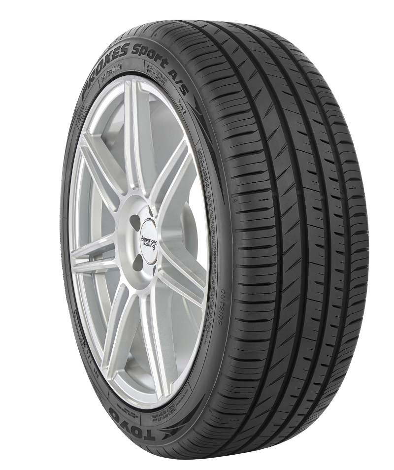 A close-up of a Toyo Proxes A/S Tire, model 285/35R18 101Y XL, displays its detailed tread pattern. Mounted on a silver five-spoke alloy wheel, the TOYO brand is prominently visible on the sidewall.