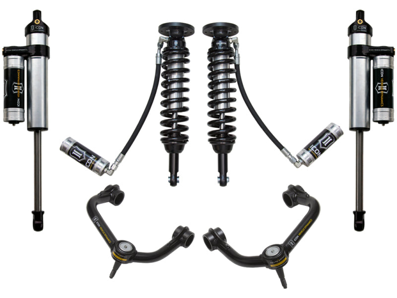 The image showcases the ICON 09-13 Ford F-150 4WD 1.75-2.63in Stage 4 Suspension System with Tubular Upper Control Arms, featuring two coilover shocks with black coils and silver bodies, alongside upper control arms equipped with Delta Joint technology for improved performance. These sleek black control arms are highlighted by yellow ICON branding, emphasizing their corrosion resistance.