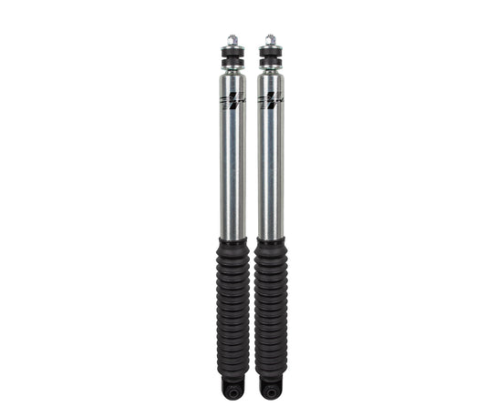 Two silver shock absorbers with black protective covers stand upright against a white background, highlighting the Carli Suspension Signature Series 2.0" IFP Front Shock Set for 05-23 Ford F-250/F-350 4WD models with a 2.5" lift and engine options of 6.2 or 7.3 liters.