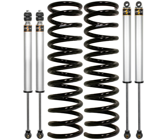 The image displays components from the Carli Suspension 13-23 Ram 3500 (4WD - Leaf) Diesel 2.5" Lift Carli-Spec Leveling System, featuring two black metal coil springs and two silver shock absorbers with black ends. These parts are arranged vertically against a plain white background, emphasizing their compatibility with the Ram 3500 Diesel for achieving a 2.5” lift.