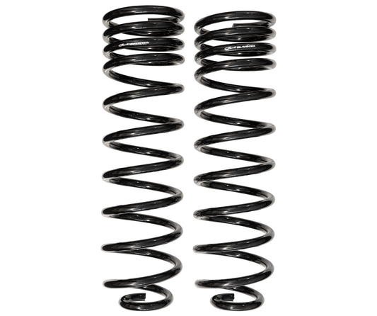 Two identical black coil springs stand parallel against a white background, highlighting their helical design. These rugged Carli Suspension multi-rate coil springs for the 19-23 Ram 1500 (4WD - Coil/Coil) REBEL with a 0.5" lift promise durability and adaptability for challenging terrains.