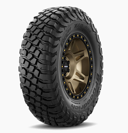 The BFGoodrich Baja T/A KR2 SC 30x9.50R15 LT Short Corse is a rugged off-road tire with deep tread patterns, designed for challenging terrains. This black tire with prominent sidewall text sits against a plain white background, featuring durable bronze alloy wheels perfect for tough conditions.