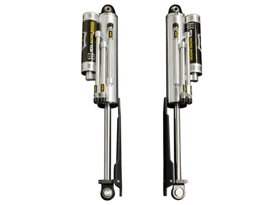 A pair of ICON 10-14 Ford Raptor Rear 3.0 Zeta Series Shocks PB is positioned side by side on a white background, evoking a sense of Ford SVT Raptor Shocks. Designed for automotive or off-road vehicles, these silver shocks feature attached black and yellow reservoirs and boast easy-to-adjust knobs to deliver optimal suspension performance.