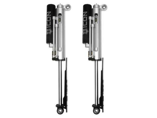 A pair of sleek ICON 2017+ Ford Raptor Rear 3.0 Series Shocks PB in silver featuring black accents are showcased vertically against a white background. Perfect for the Ford Raptor, these shocks include attached reservoirs and intricately detailed mechanical components, embodying precision engineering.