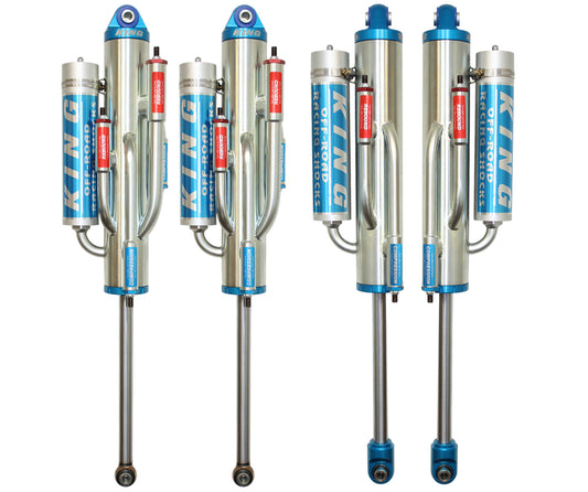 Four upright Carli Suspension 3.0" BP shocks for the 05-16 Ford F-250/F-350 (4WD) with a 4.5" lift feature a sleek silver and blue design and external reservoirs, highlighting their off-road capability. These high-performance bypass shocks come with branded protective covers on the reservoirs, making them an ideal choice for enhancing rugged vehicles.