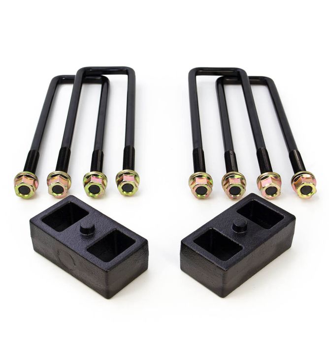 The LTW Motorsports 19-23 GM 1500 1 Inch Block and U-Bolt Kit features a symmetrical arrangement of four black U-bolts with gold-toned hexagon nuts and two black cast iron rectangular blocks, each with two recessed sections, displayed on a white background. Perfect for Rear Block Kits, these components provide both functionality and visual appeal.