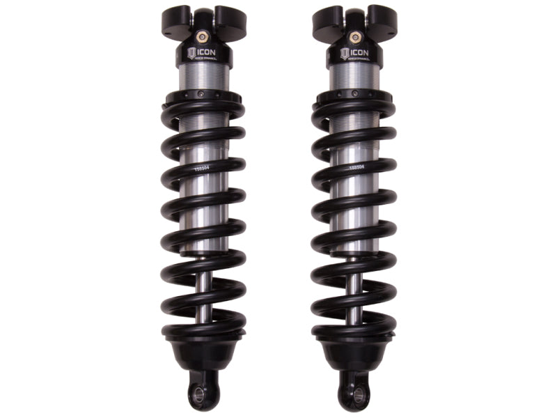 Two black, adjustable coil-over shocks, part of the ICON 96-04 Toyota Tacoma / 96-02 Toyota 4Runner 2.5 Series Shocks VS IR Coilover Kit, are displayed against a white background. Each shock consists of a coiled spring around a race-proven shock absorber with mounting brackets at both ends. The brand logo "ICON" is visible near the top.